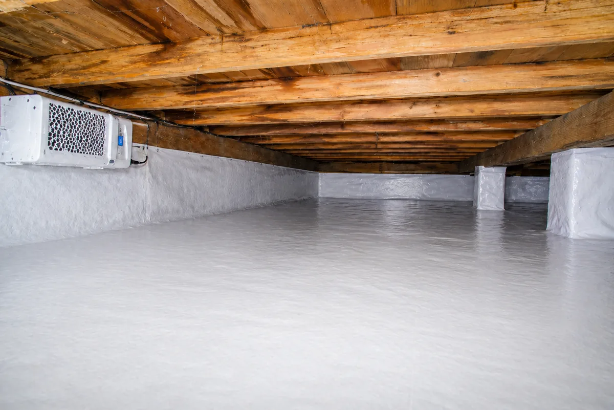Completed DIY crawl space encapsulation with white vapor barrier covering floor and walls, professionally finished